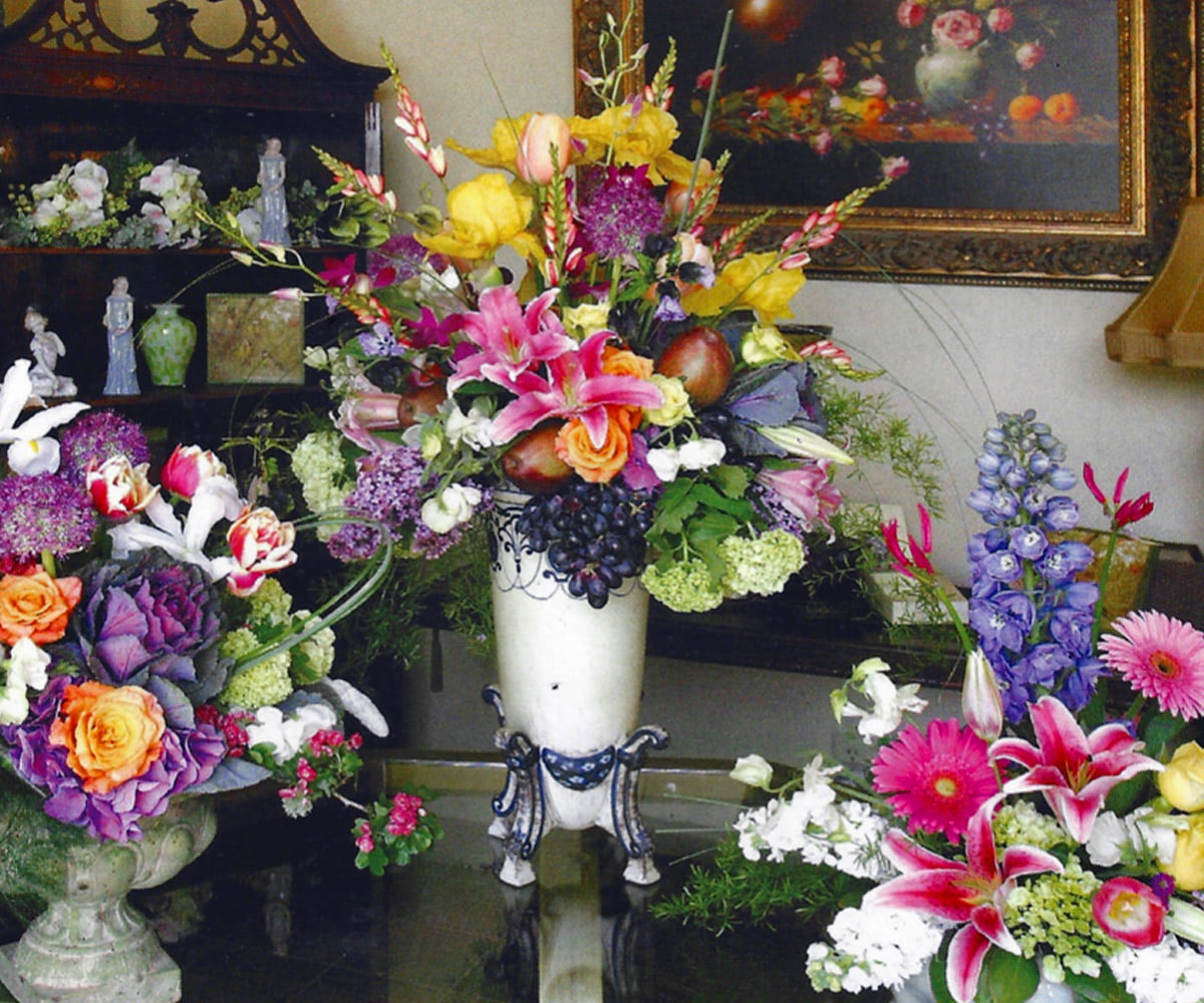 Three bright, matching bouquets behind the counter of our Salinas showroom