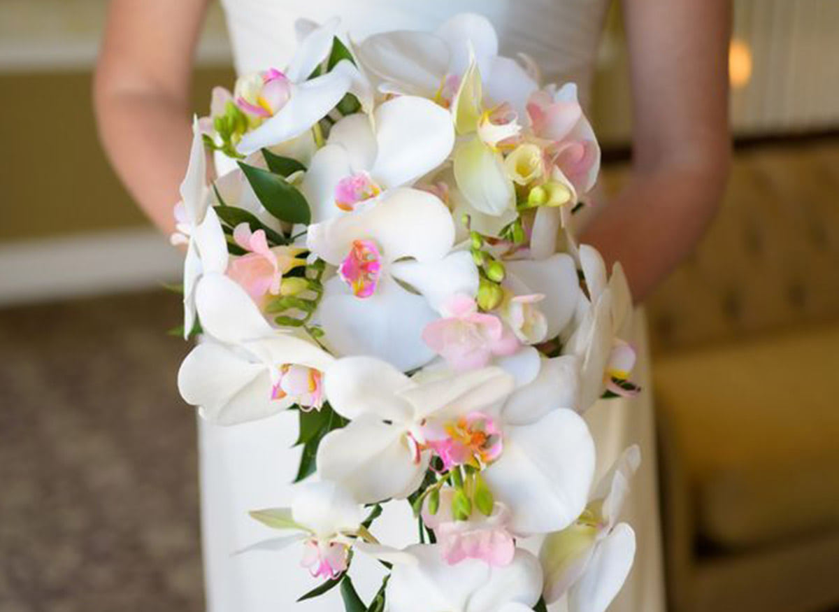 Stunning white orchids in the arms of a beautiful bride